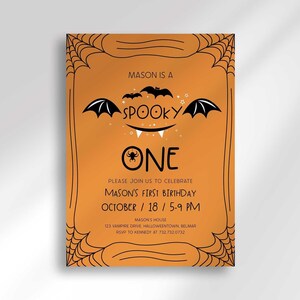 A full view of Mason's Halloween-themed 'Spooky One' first birthday invitation on an orange background with a black spiderweb border and hand-drawn bat illustrations.