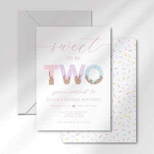 The ice cream-themed 'Sweet to be TWO' invitation for Olivia angled in front of its matching white envelope.