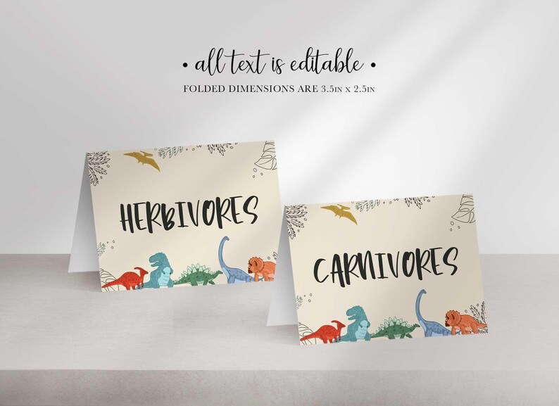 Two folded tent cards with dinosaur illustrations display the words HERBIVORES and CARNIVORES.