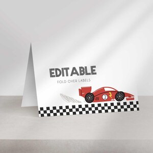 A single white folded tent card on a shelf, showing a black and white checkered border, editable text, and a red race car graphic.