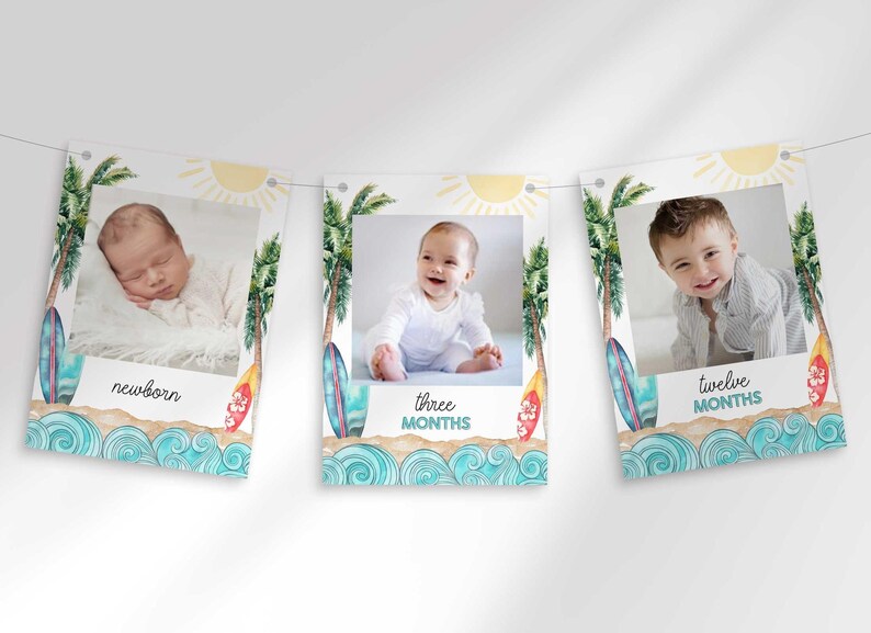 Three rectangular cards hang on a string, featuring a watercolor beach theme with surfboards, palm trees, ocean waves, and baby photos labeled newborn, three months, and twelve months.