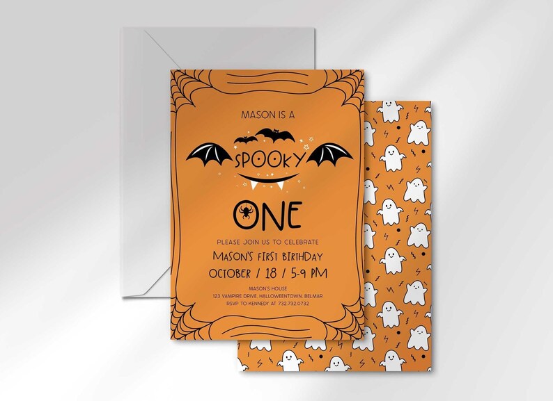 Mason's Halloween-themed 'Spooky One' first birthday invitation layered in front of its matching envelope and a second card showing an orange back design with a white ghost pattern.