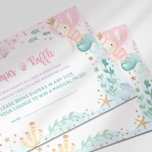 Angled close-up of two printed mermaid themed diaper raffle cards overlapping, showing the coral, shell, and starfish design.