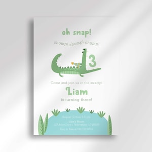 May include: A birthday invitation with a green alligator illustration and the text "oh snap!" and "Liam is turning three!" The invitation has a light green and blue color scheme, with a swamp theme.