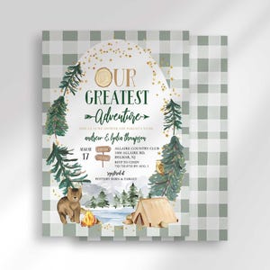 Andrew and Lydia's camping-themed baby shower invitation with a second card showing a sage green plaid back design peeking out behind it.