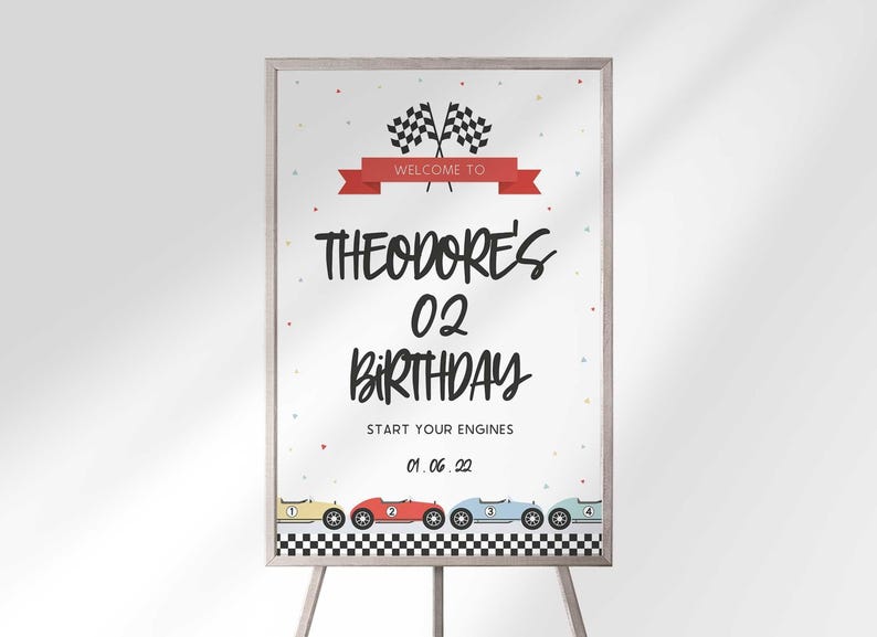 A framed race car birthday welcome sign on an easel displaying Theodore's 02 Birthday with checkered flags and vintage race cars.