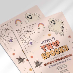 Angled close-up of Olivia's Halloween-themed second birthday invitation, showing the ghost, spiderweb, and pumpkin illustrations with party details.