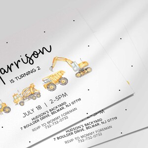 Close-up angled view of multiple printed construction truck birthday invitations fanned out to show the design detail.