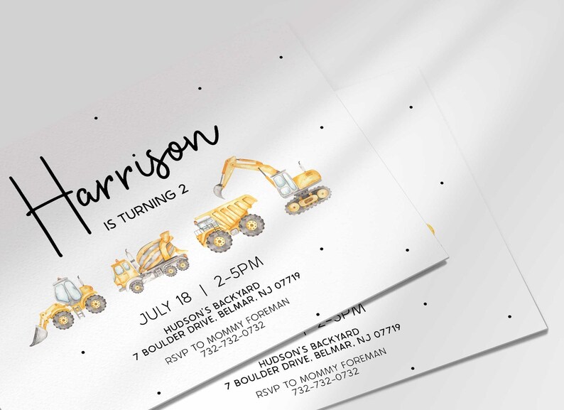 Close-up angled view of multiple printed construction truck birthday invitations fanned out to show the design detail.