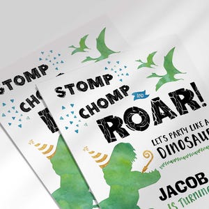 An angled close-up view of Jacob's dinosaur-themed birthday invitation, showing the 'Stomp Chomp Roar!' title and green dinosaur illustration.