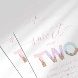 Close-up angled shot of the 'Sweet to be TWO' ice cream-themed invitation for Olivia's second birthday, showing the print quality and ice cream cone lettering detail.