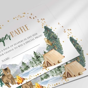 Close-up angled shot of two printed Diaper Raffle cards fanned out, showing the woodland camping design detail up close.