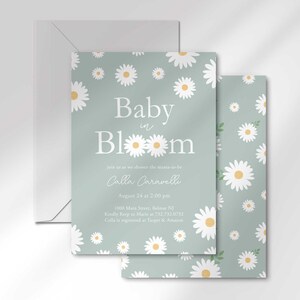 The 'Baby in Bloom' invitation for Calla Caravelli layered in front of its matching envelope and a second card showing the daisy pattern back design.