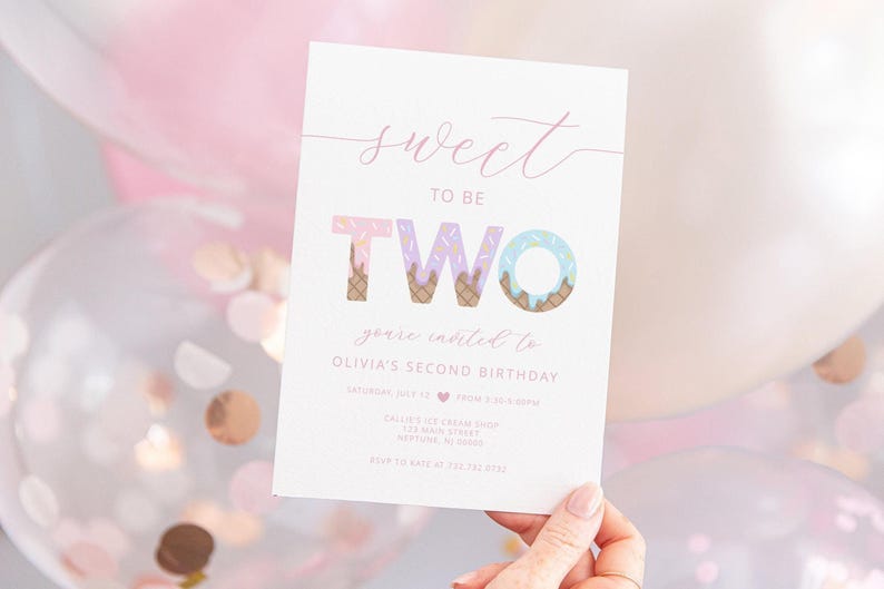 Lifestyle photo of an ice cream-themed second birthday invitation for Olivia, held by a hand against a backdrop of pink balloons and confetti. The invitation reads 'Sweet to be TWO, you're invited to Olivia's second birthday' with illustrated ice cream cones forming the word 'TWO.'