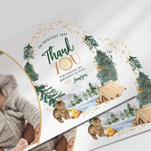Angled close-up of Jameson's camping-themed thank you photo card with the baby's photo mockup, showing the pine tree and bear illustrations with the thank you message.