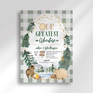Camping-themed baby shower invitation on a sage green plaid background with illustrated pine trees, a bear, a tent, and a campfire scene, reading "Our Greatest Adventure, join us as we shower the parents-to-be, Andrew & Lydia Thompson" with the party date, time, and location.