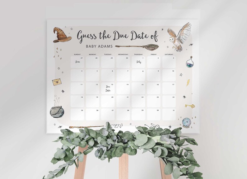Harry Potter themed guess the due date calendar sign on an easel styled with a eucalyptus greenery garland draped along the bottom.