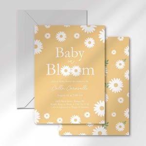 The 'Baby in Bloom' invitation for Calla Caravelli layered in front of its matching envelope and a second card showing the daisy pattern back design.