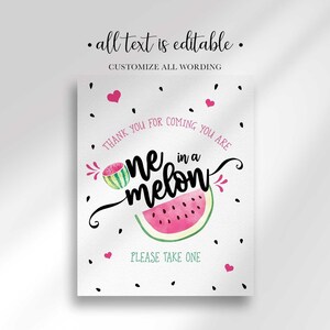 A party sign that reads You are One in a Melon with watermelon graphics, pink hearts, and black seeds.