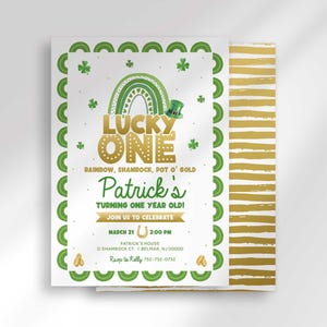 Primary listing photo of a Lucky One St. Patrick's Day first birthday invitation, green shamrock border and gold rainbow illustration over a gold striped background, personalized text reading Patrick's Turning One Year Old with party date, time, and address details.