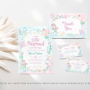 Flat lay of a matching mermaid baby shower stationery suite with a dried palm frond, including the Little Mermaid Is On The Way invitation, a thank you card, a diaper raffle card, and a books and cuddles card, with text noting matching printables are sold separately and bundled in my shop.