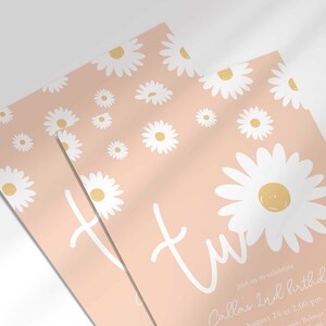 Close-up angled shot of the 'TWO' daisy-themed invitation for Callie's 2nd birthday in pink, showing the print quality and daisy pattern detail.