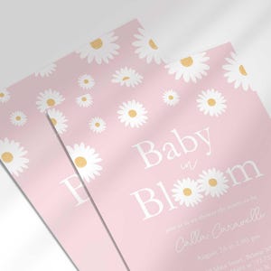 Close-up angled stack of two prints of the 'Baby in Bloom' daisy-themed invitation for Calla Caravelli, showing the print quality and daisy pattern detail.