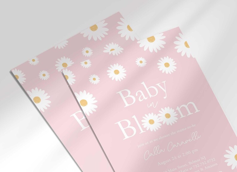 Close-up angled stack of two prints of the 'Baby in Bloom' daisy-themed invitation for Calla Caravelli, showing the print quality and daisy pattern detail.