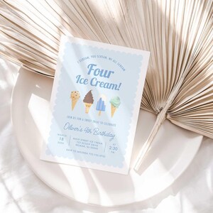 Styled flat lay of the Four Ice Cream fourth birthday invitation resting on a white plate with a dried palm leaf and linen backdrop.