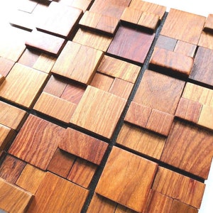 Può includere: Una piastrella da parete in legno con un design geometrico 3D. La piastrella è realizzata in diverse tonalità di legno marrone e ha un aspetto naturale e rustico.