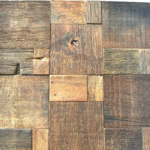 May include: A wall panel made from reclaimed wood, featuring a rustic, distressed look. The panel is composed of various sized squares of wood, each with a different grain pattern and colour. The wood is a mix of brown, grey, and beige tones.