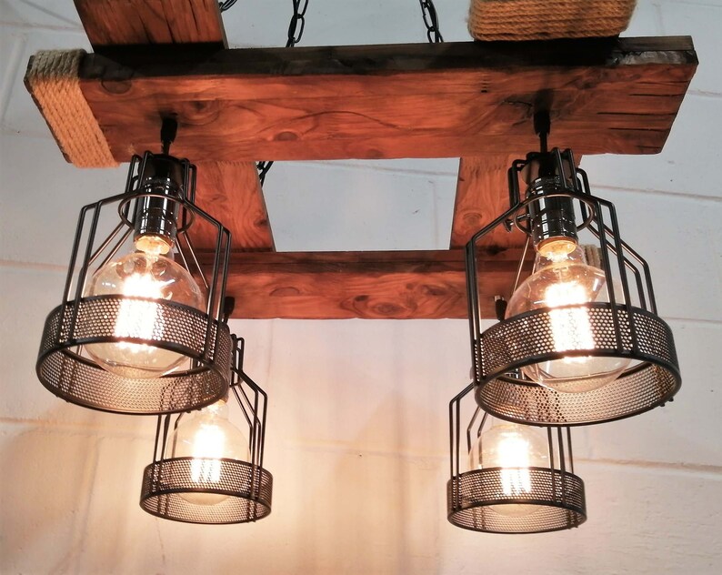 May include: A rustic wooden chandelier with four black metal cage light fixtures. The chandelier is suspended from a chain and has a rope detail on the top.