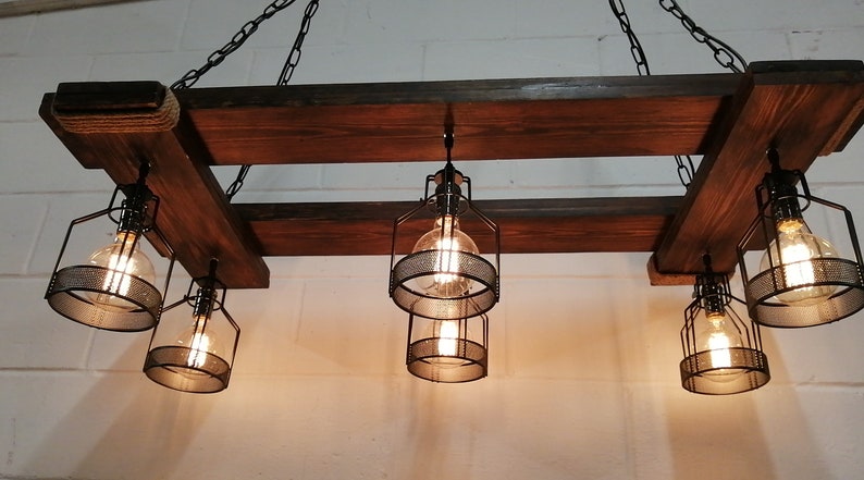 May include: A rustic wooden chandelier with six caged light bulbs. The chandelier is made of reclaimed wood and has a farmhouse style.