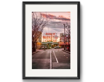May include: A photograph of the Public Market Center sign in Seattle, Washington. The sign is lit up with red neon letters against a backdrop of a cloudy sky. The street in front of the sign is empty, with a few cars parked on the side.