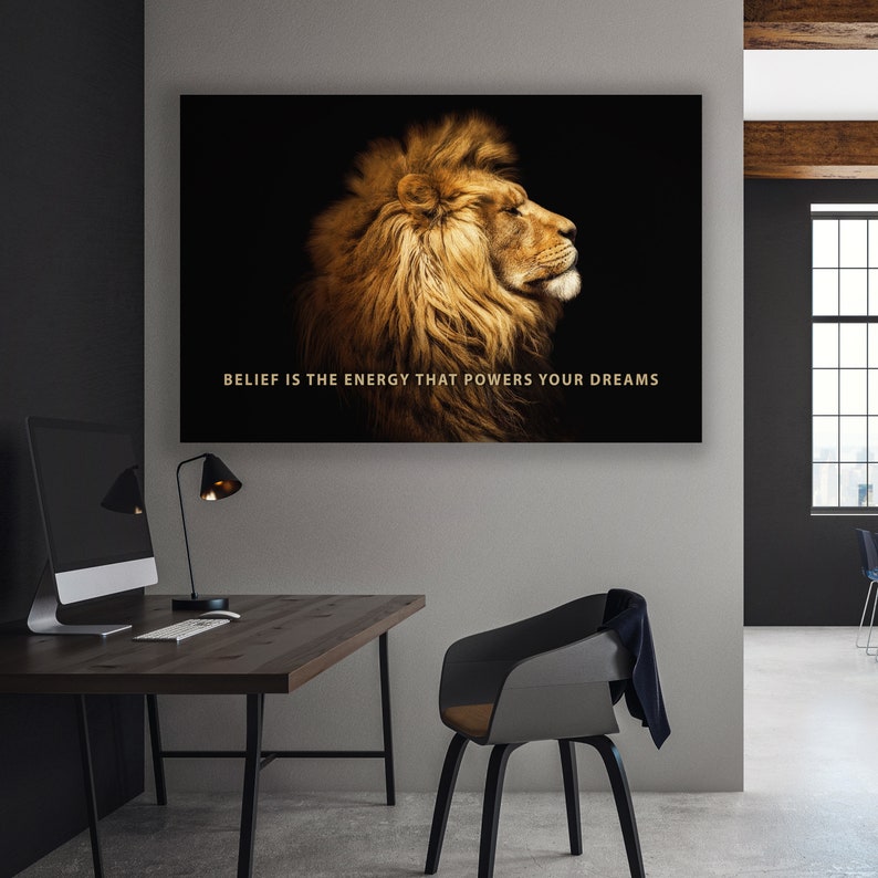 Pode incluir: Uma cita&ccedil;&atilde;o motivacional, "BELIEF IS THE ENERGY THAT POWERS YOUR DREAMS", &eacute; exibida em um fundo preto com um perfil de cabe&ccedil;a de le&atilde;o dourado.