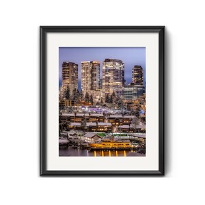 May include: A nighttime cityscape with tall buildings lit up against a purple sky. The buildings are covered in snow and there are trees in the foreground. A boat is docked in the water in front of the buildings.
