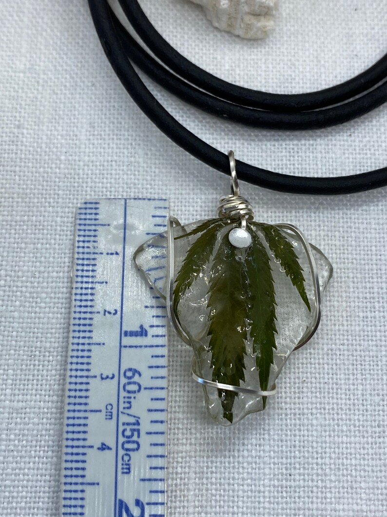 Handmade cannabis necklaces preserved on sea glass and coated in resin