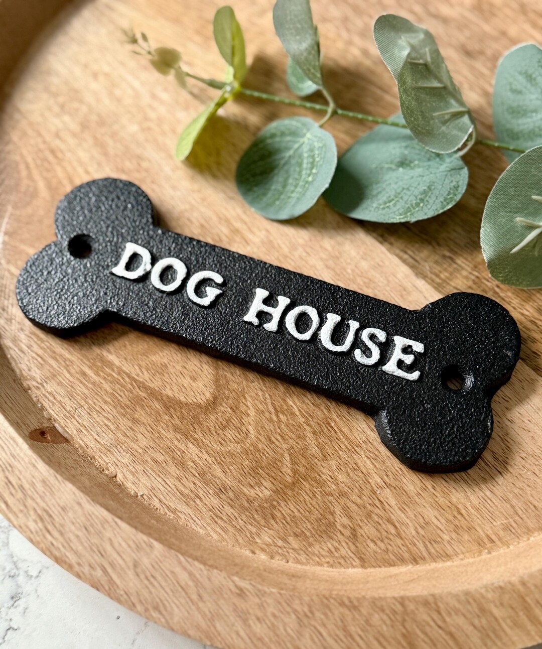 A Cast Iron Sign DOG HOUSE Black Background With White Text
