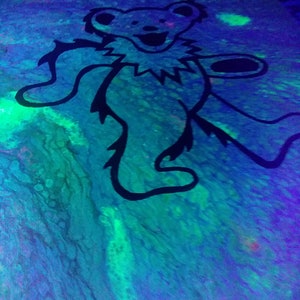 May include: Black and white silhouette of a dancing bear on a blue, green, and purple background with a swirling, marbled effect.