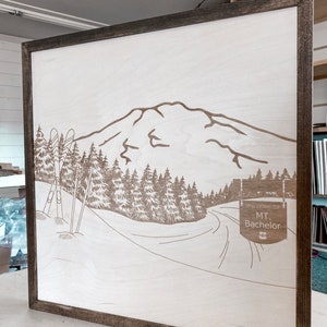 Puede incluir: Un letrero de madera con un dise&ntilde;o de monta&ntilde;a, &aacute;rboles y bastones de esqu&iacute; cortado con l&aacute;ser. El letrero dice "Bienvenido a Mt. Bachelor".