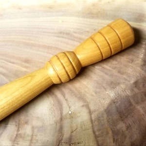 May include: A wooden rolling pin with a textured handle. The handle is made of light wood and has a series of ridges.