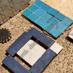 May include: Assortment of blue, white, and gray ceramic tiles with geometric patterns. The tiles are arranged in a square shape and are ready to be used for a home decor project.