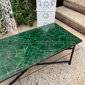 Puede incluir: Una mesa de caf&eacute; de azulejos verdes con un marco de metal negro. La mesa tiene un patr&oacute;n geom&eacute;trico y el texto "FARAH DECOR SOUDAGE" es visible en la superficie.