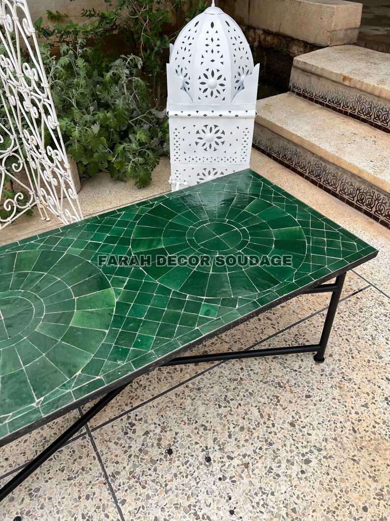 Puede incluir: Una mesa de caf&eacute; de azulejos verdes con un marco de metal negro. La mesa tiene un patr&oacute;n geom&eacute;trico y el texto "FARAH DECOR SOUDAGE" es visible en la superficie.
