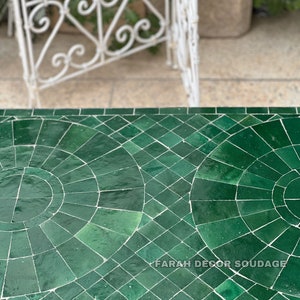 Puede incluir: Una mesa de mosaico verde marroqu&iacute; con marco de metal negro. La mesa est&aacute; hecha de peque&ntilde;os azulejos verdes dispuestos en un patr&oacute;n geom&eacute;trico. El texto "FARAH DECOR SOUDAGE" es visible en la mesa.