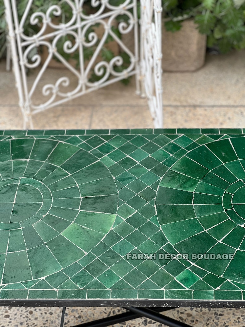 Puede incluir: Una mesa de mosaico verde marroqu&iacute; con marco de metal negro. La mesa est&aacute; hecha de peque&ntilde;os azulejos verdes dispuestos en un patr&oacute;n geom&eacute;trico. El texto "FARAH DECOR SOUDAGE" es visible en la mesa.