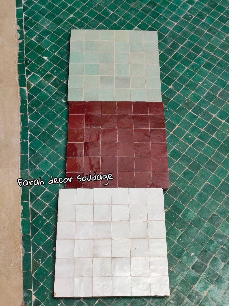 May include: Three square tiles, each with a different color. The top tile is light green, the middle tile is dark red, and the bottom tile is white. The tiles are arranged vertically, with the top tile at the top of the image and the bottom tile at the bottom of the image. The tiles are all made of the same material, and they have a smooth, glossy finish.