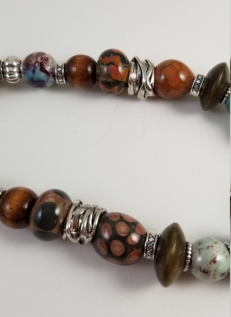 Frog bead necklace with handblown glass ceramic and wood beads on blue gray blue suede leather cord with a heart lobster claw clasp.