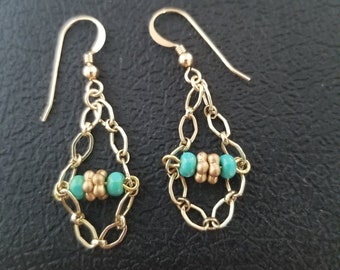 14 kt gold filled earrings with turquoise glass beads and gold spacers dangling on chain on French hook ear wires.