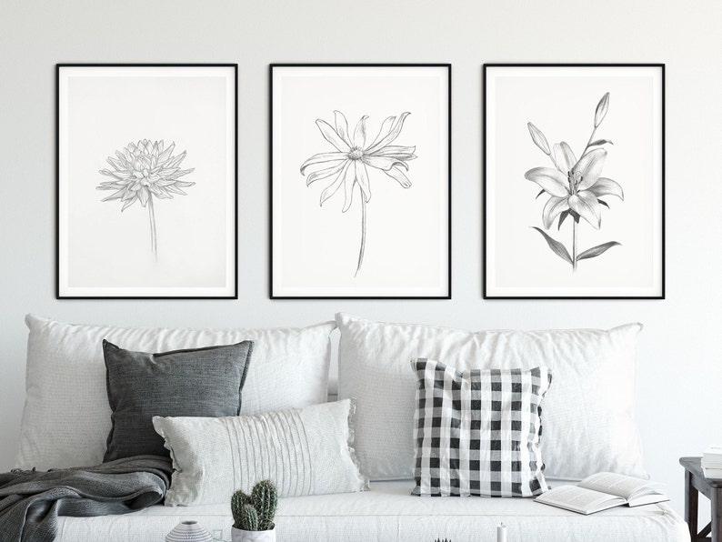 Pu&ograve; includere: Tre stampe in bianco e nero incorniciate di illustrazioni botaniche. Le stampe raffigurano una dalia, una margherita e un giglio.